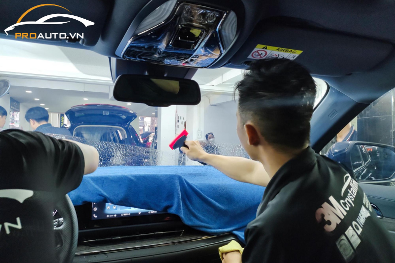 Kỹ thuật viên thi công dán phim cách nhiệt cho kính lái xe ô tô 