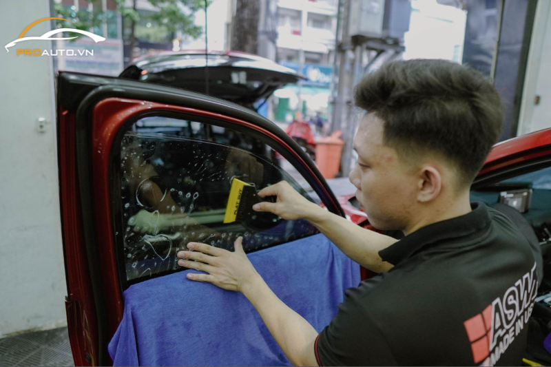 Kỹ thuật viên thi công dán phim cách nhiệt xe Toyota Innova